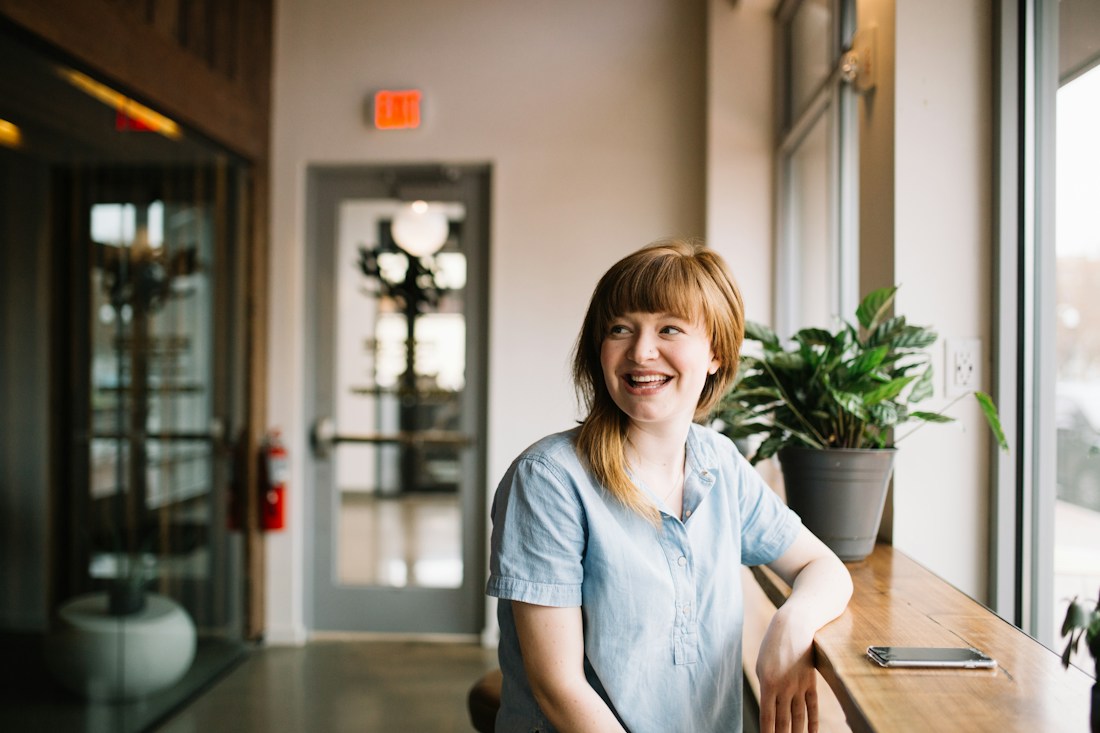 Business professional seated beside a window